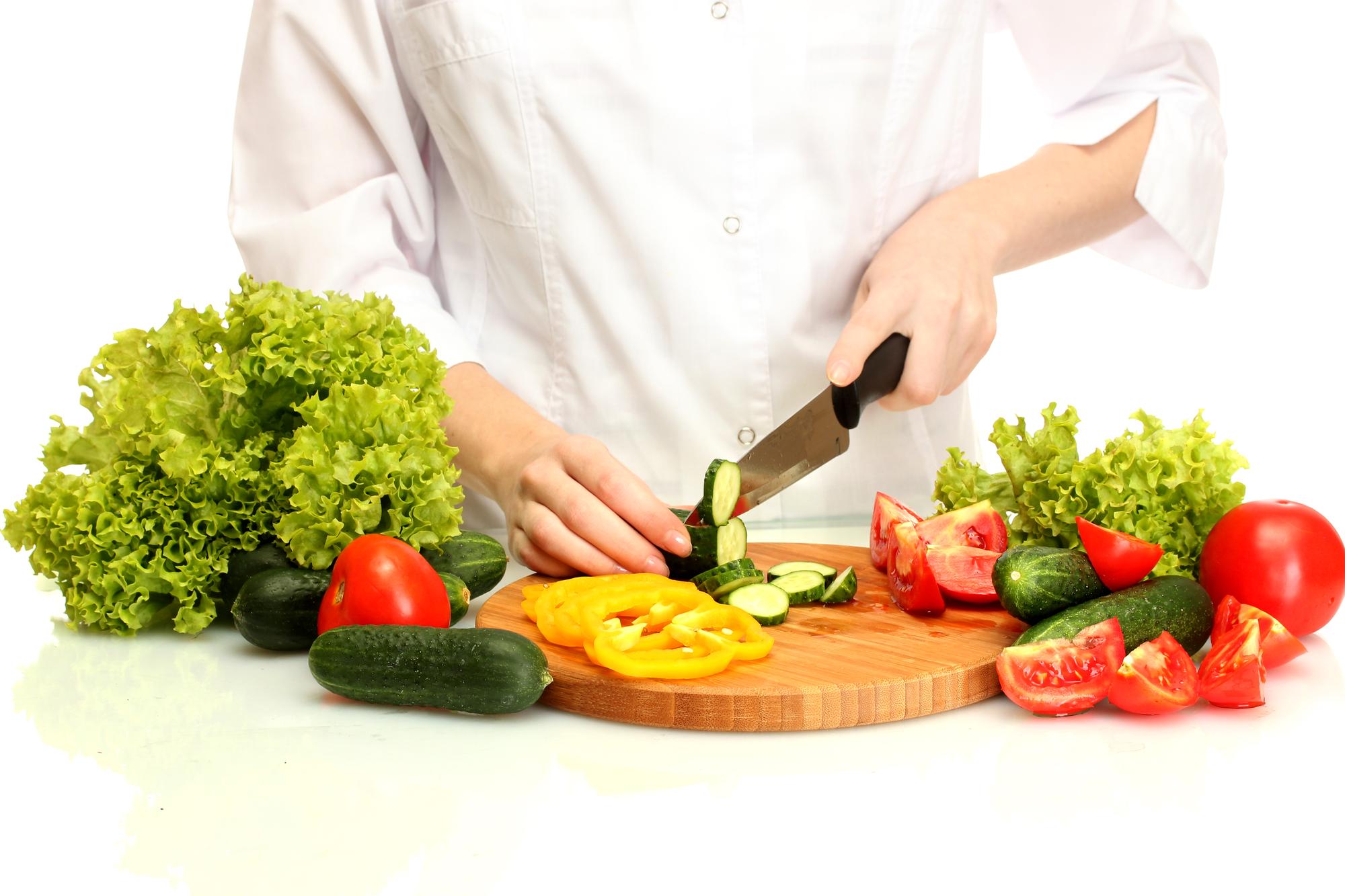 Student chopping vegetables during class